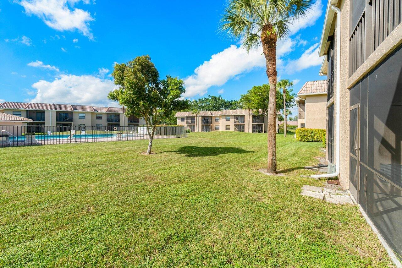 6736 Palmetto Circle South, Unit 105 Boca Raton, FL 33433 - Photo 23 of 28 a view of a house with a yard