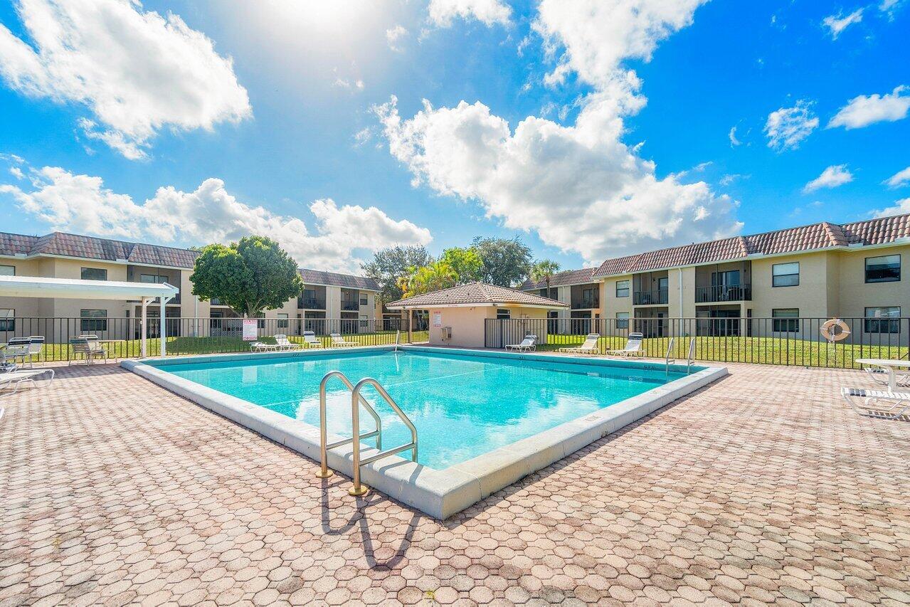 6736 Palmetto Circle South, Unit 105 Boca Raton, FL 33433 - Photo 27 of 28 a view of a house with swimming pool and sitting area