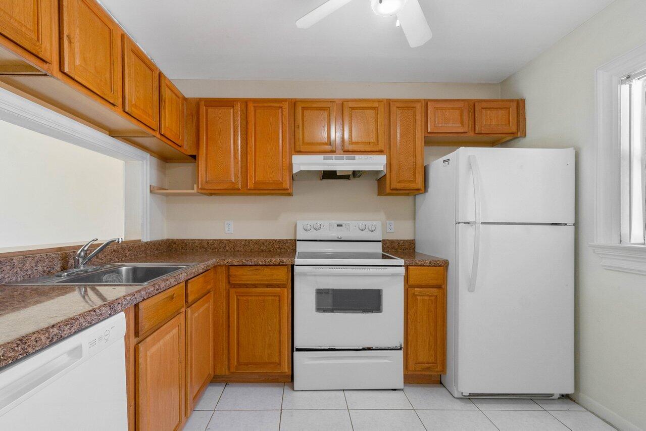 6736 Palmetto Circle South, Unit 105 Boca Raton, FL 33433 - Photo 4 of 28 a kitchen with stainless steel appliances granite countertop a refrigerator and a sink