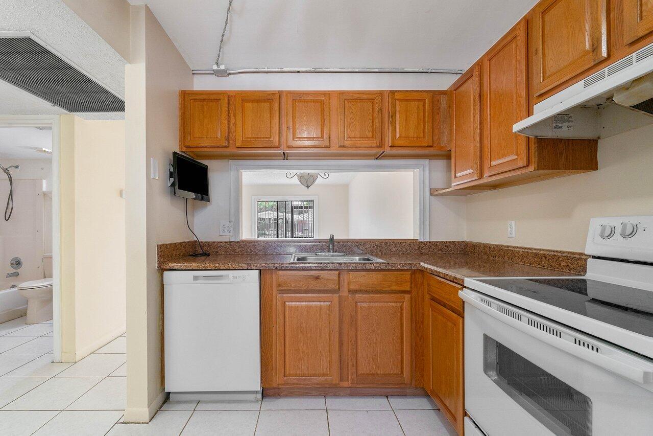 6736 Palmetto Circle South, Unit 105 Boca Raton, FL 33433 - Photo 6 of 28 a kitchen with stainless steel appliances granite countertop a stove and a refrigerator