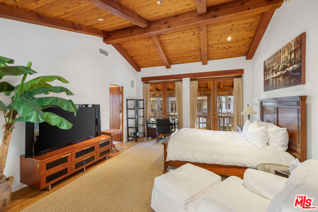 25127 Jim Bridger Road Hidden Hills, CA 91302 - Photo 28 of 50 a bedroom with furniture and large windows