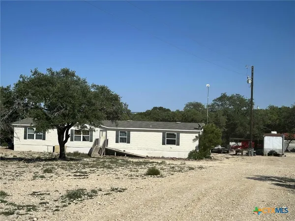 a view of a dry backyard with a house