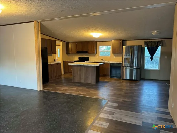 a view of kitchen with stainless steel appliances granite countertop cabinets and wooden floor