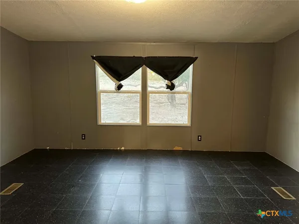 an empty room with wooden floor and a window
