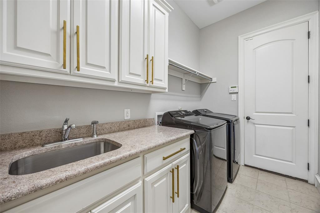 134 Santa Rosa Way Irving, TX 75062 - Photo 12 of 26 Spacious laundry room with built-in cabinetry, countertop workspace, and room for a full-size washer and dryer.