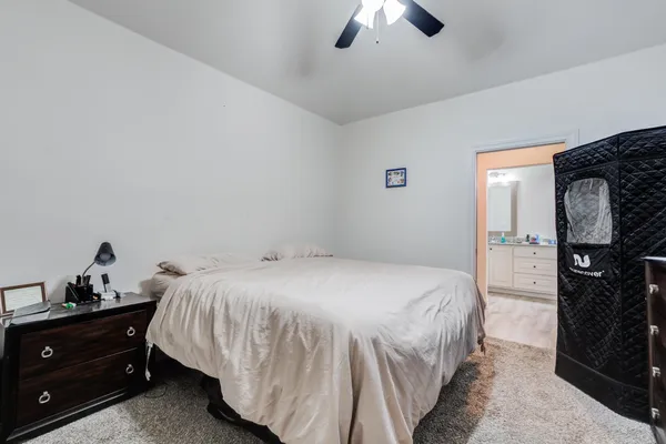 a bedroom with a bed and a mirror on dresser