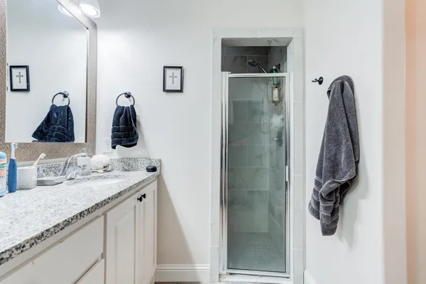 a bathroom with a granite countertop sink and a mirror