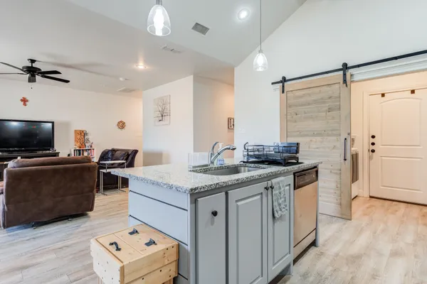 a kitchen with a stove and a flat screen tv
