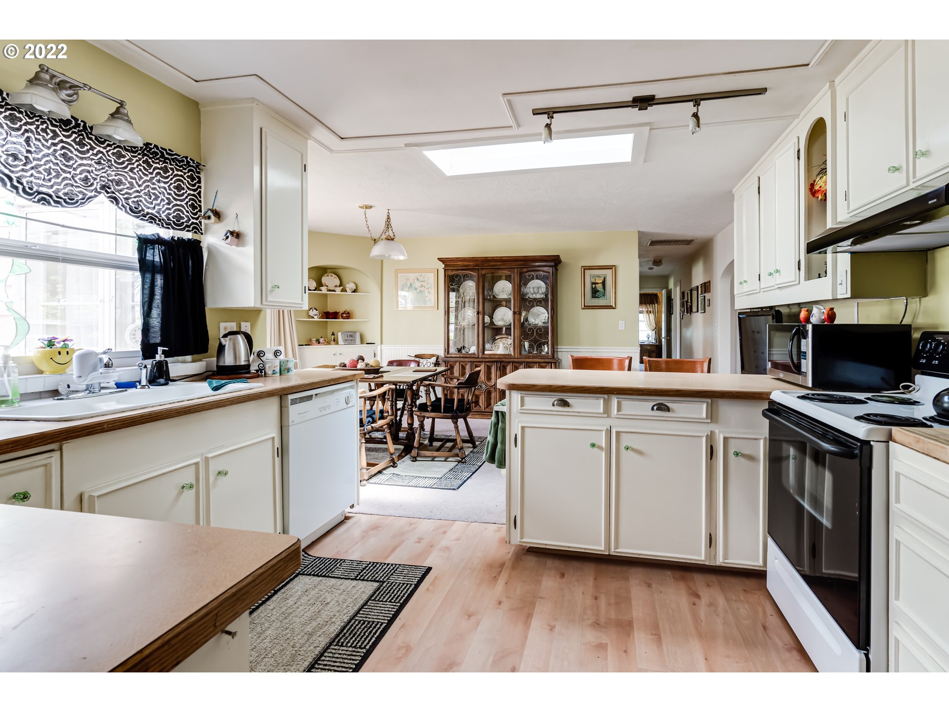 369 Knoop Lane Eugene, OR 97404 - Photo 15 of 32 a open kitchen with stainless steel appliances granite countertop a stove a sink dishwasher and white cabinets with wooden floor
