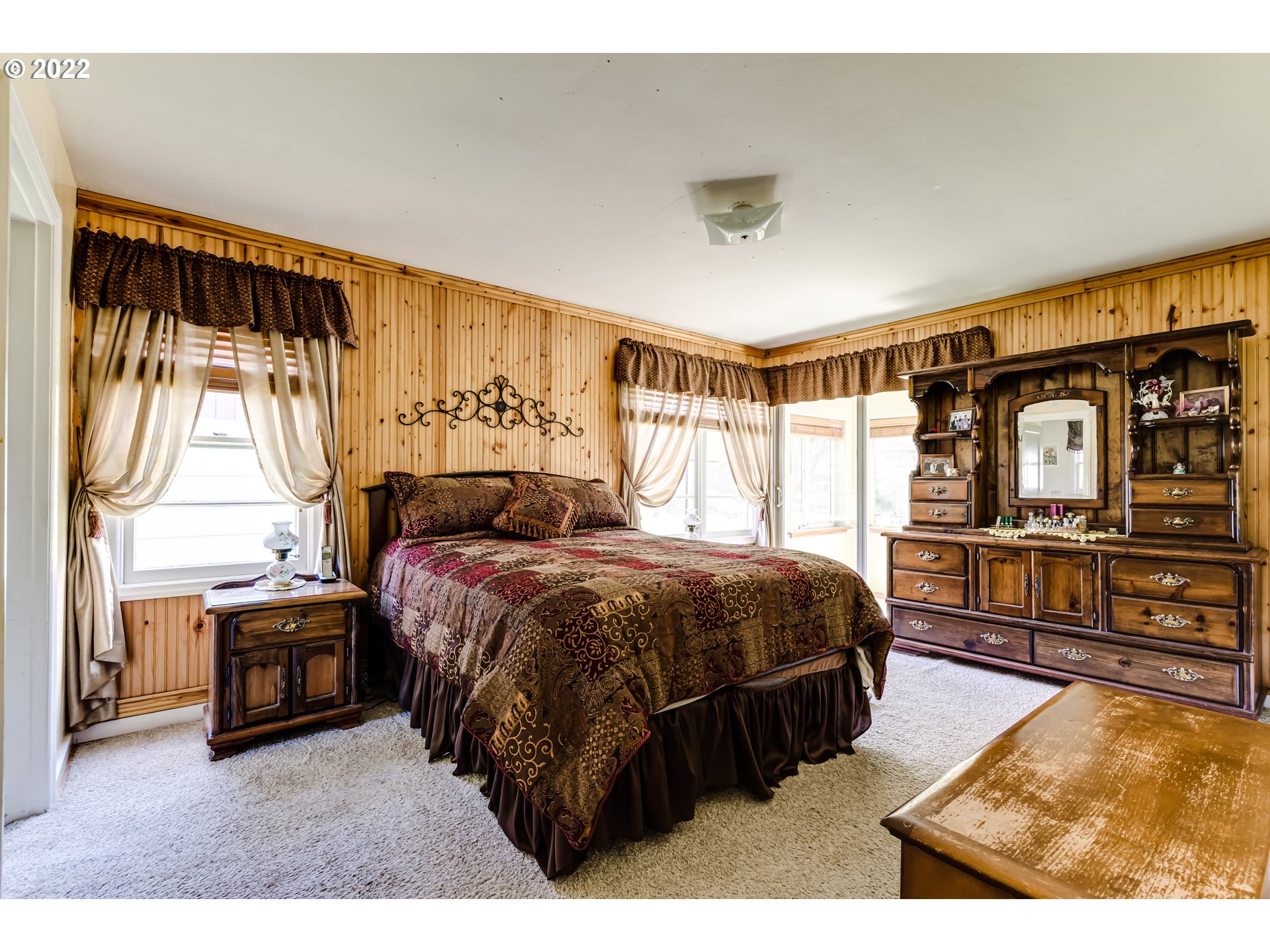 369 Knoop Lane Eugene, OR 97404 - Photo 21 of 32 a spacious bedroom with a bed a dresser and windows