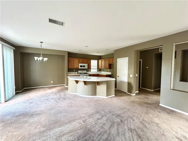 a large kitchen with kitchen island a sink stainless steel appliances and cabinets