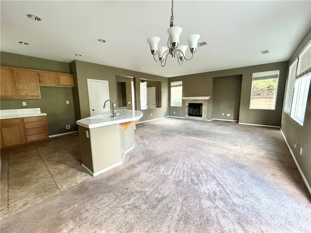 a view of a big room with windows and chandelier