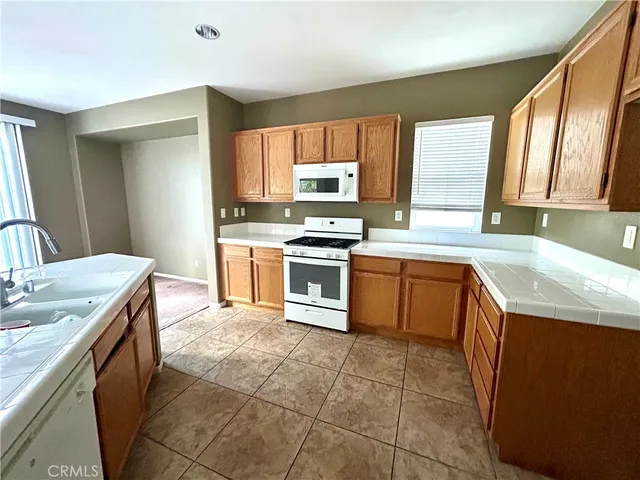 a kitchen with a stove sink and cabinets