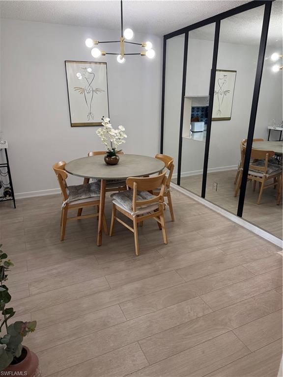315 St Andrews Boulevard, Unit A2 Naples, FL 34113 - Photo 13 of 17 a dining room with furniture and a chandelier
