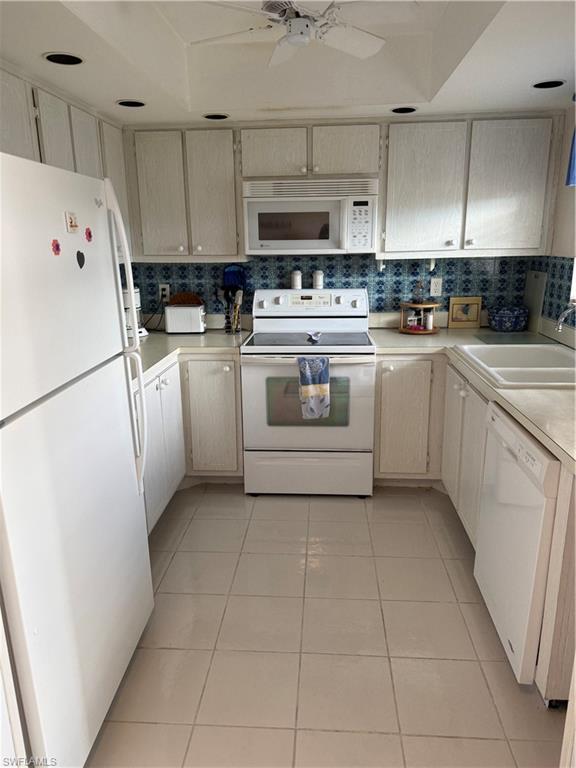 315 St Andrews Boulevard, Unit A2 Naples, FL 34113 - Photo 14 of 17 a kitchen with stainless steel appliances a refrigerator sink and white cabinets