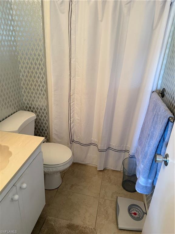 315 St Andrews Boulevard, Unit A2 Naples, FL 34113 - Photo 8 of 17 a white toilet sitting next to a white sink and vanity