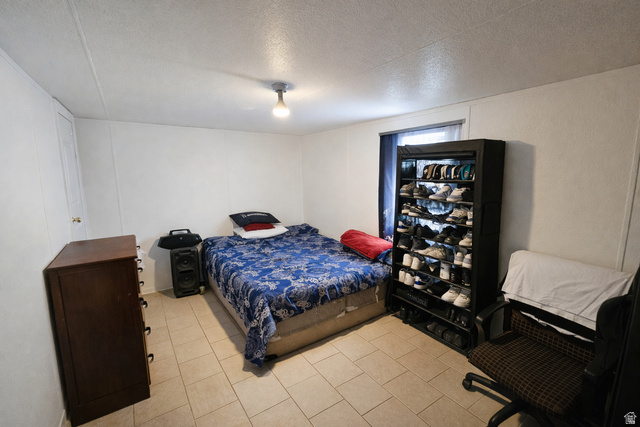 340 West 920 South, Unit 16 Provo, UT 84601 - Photo 9 of 15 Bedroom with a textured ceiling, a decorative wall, and light tile patterned floors