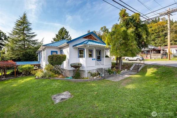a front view of a house with garden and a porch