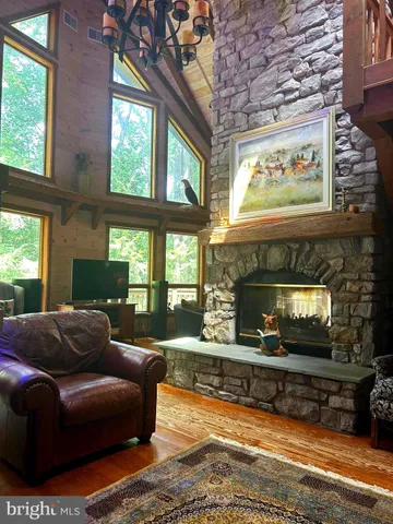a living room with fireplace furniture and a large window