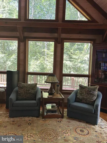 a living room with furniture a table and chairs next to a window