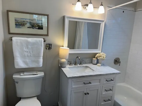 a bathroom with a granite countertop toilet sink and mirror