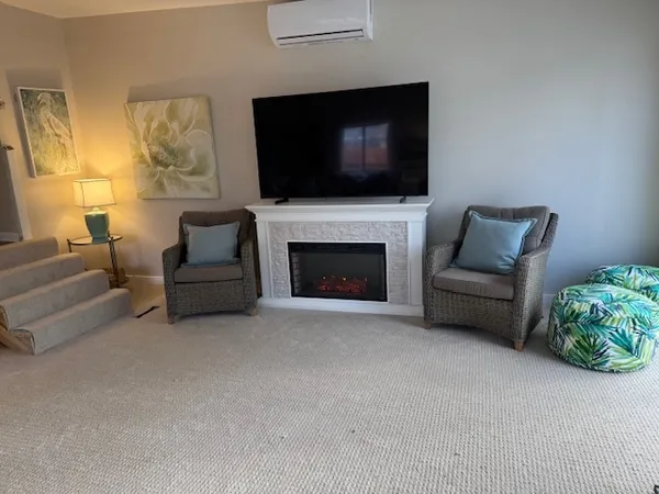 a living room with furniture a flat screen tv and a fireplace