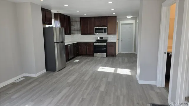 a kitchen with stainless steel appliances a refrigerator and a stove top oven