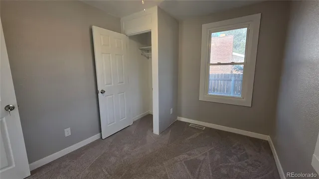 an empty room with windows and closet