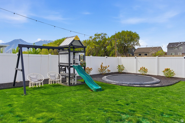 596 South Meade Street Mapleton, UT 84664 - Photo 32 of 38 View of play area with a fenced backyard, a trampoline, and a mountain view
