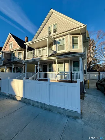 a front view of a house with a yard and potted plants