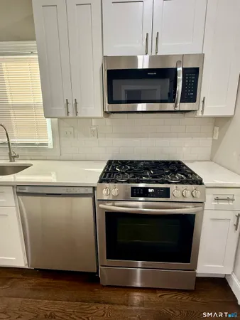 a stove top oven sitting inside of a kitchen