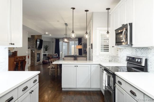 3604 Raleigh Street Denver, CO 80212 - Photo 13 of 38 a kitchen with stainless steel appliances kitchen island granite countertop a sink a stove and cabinets