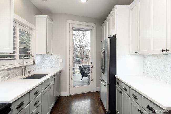 3604 Raleigh Street Denver, CO 80212 - Photo 14 of 38 a kitchen with a sink a refrigerator a window and cabinets