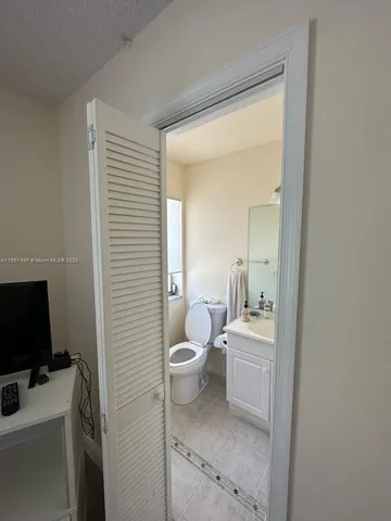 a bathroom with a toilet sink and mirror