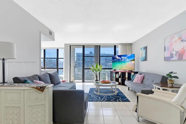 a living room with furniture and a floor to ceiling window