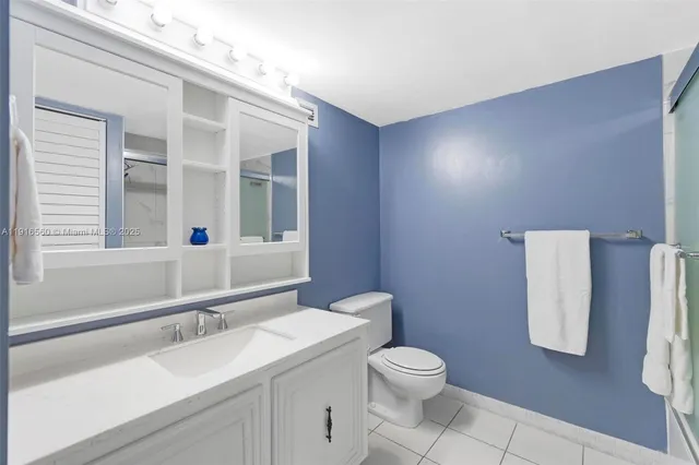 a bathroom with a granite countertop sink toilet and mirror