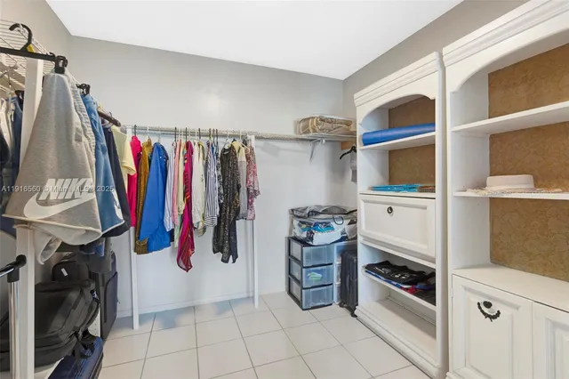 a view of walk in closet with clothes and shoes