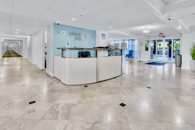 a living room with furniture and a dining table with kitchen view