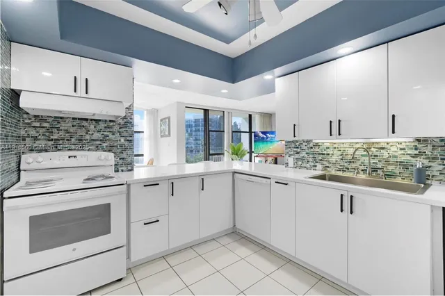 a kitchen with white cabinets and white appliances