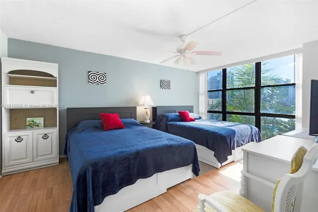 a bedroom with two beds and a large window