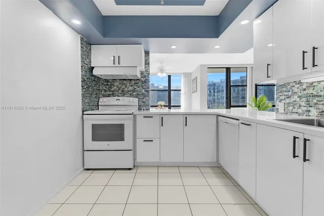 a kitchen with white cabinets and white appliances