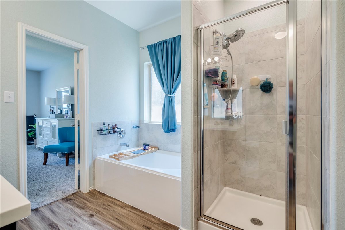 358 Jasper Trail Buda, TX 78610 - Photo 18 of 35 Glass-enclosed shower with a tiled interior and a built-in tub with tile surround