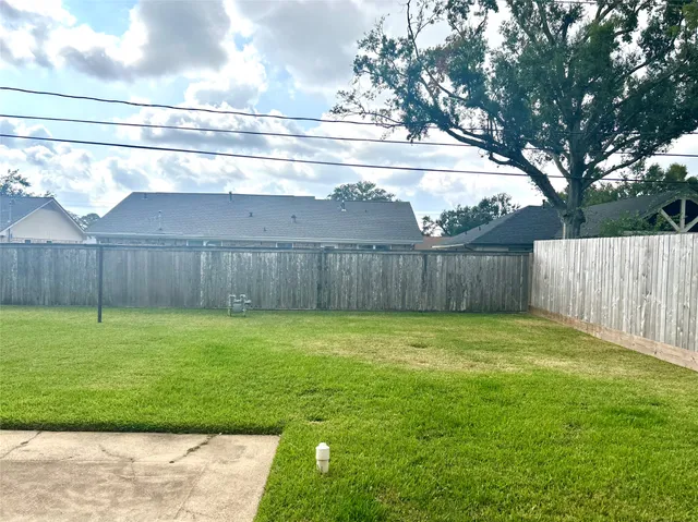 a view of a backyard with wooden fence
