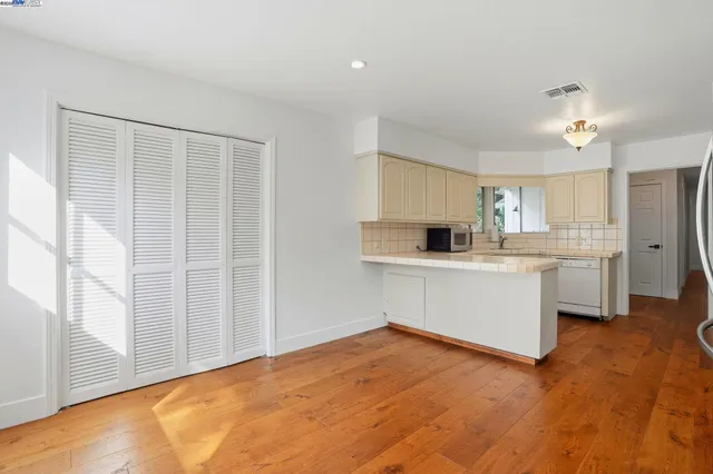 a kitchen with stainless steel appliances a refrigerator and wooden floor