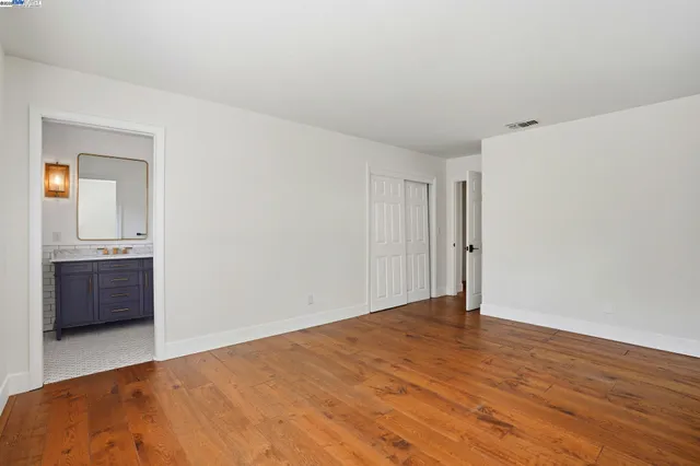 an empty room with wooden floor and a window