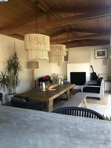 a living room with furniture a flat screen tv and kitchen view