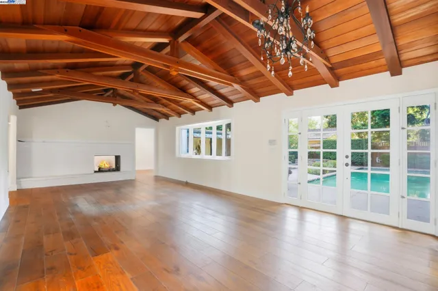 a view of a livingroom with wooden floor and a fireplace