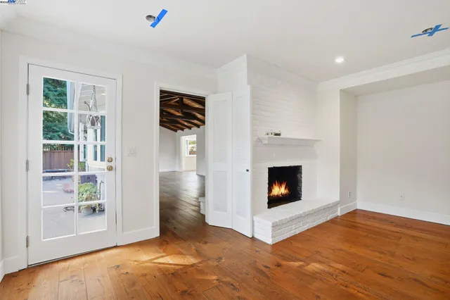 a living room with wooden floor and a fireplace