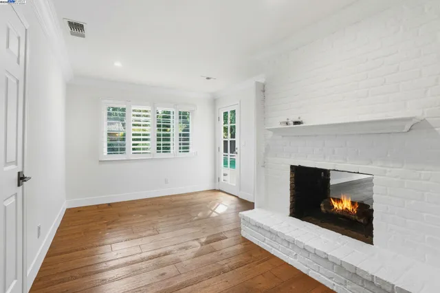 a view of a livingroom with wooden floor and fireplace