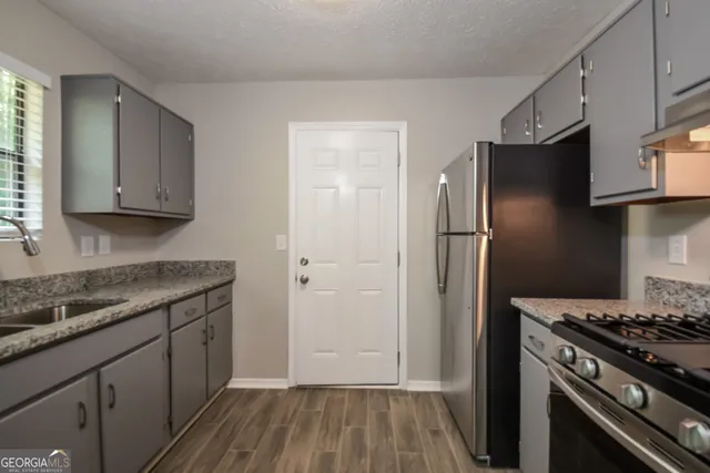 a kitchen with a sink stove and refrigerator